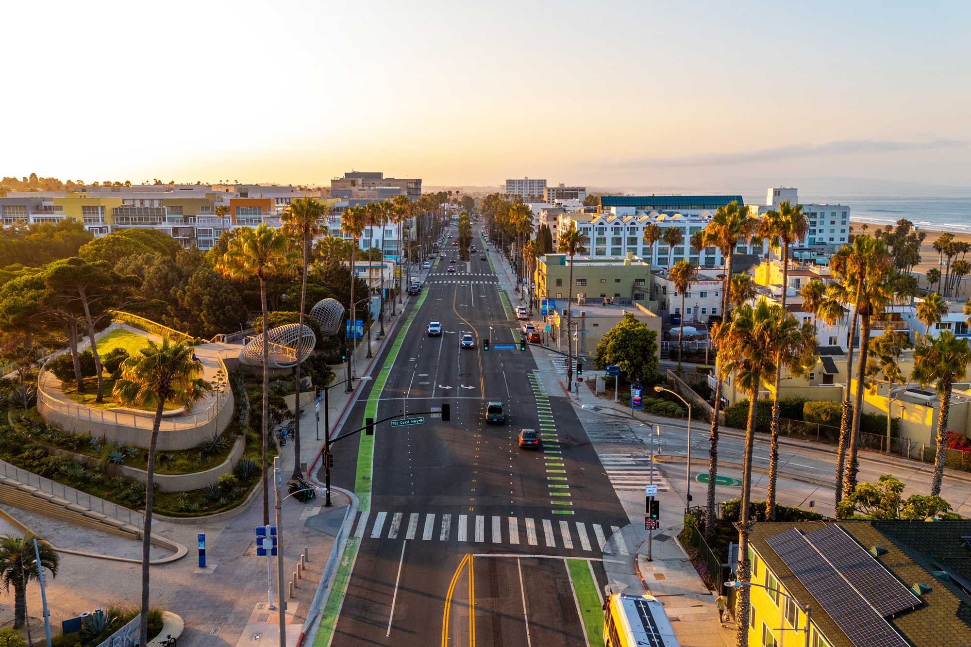 An aerial view of Santa Monica at golden hour, palm-lined streets running down toward the Pacific